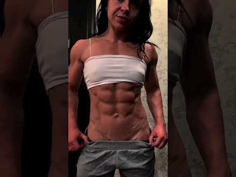 Female bodybuilder flexing shredded abs